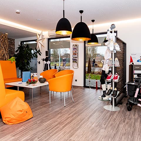 The waiting area in our medical supply store with orange chairs and an upholstered bench