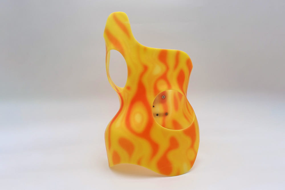A dynamically curved torso orthosis in yellow with orange pattern