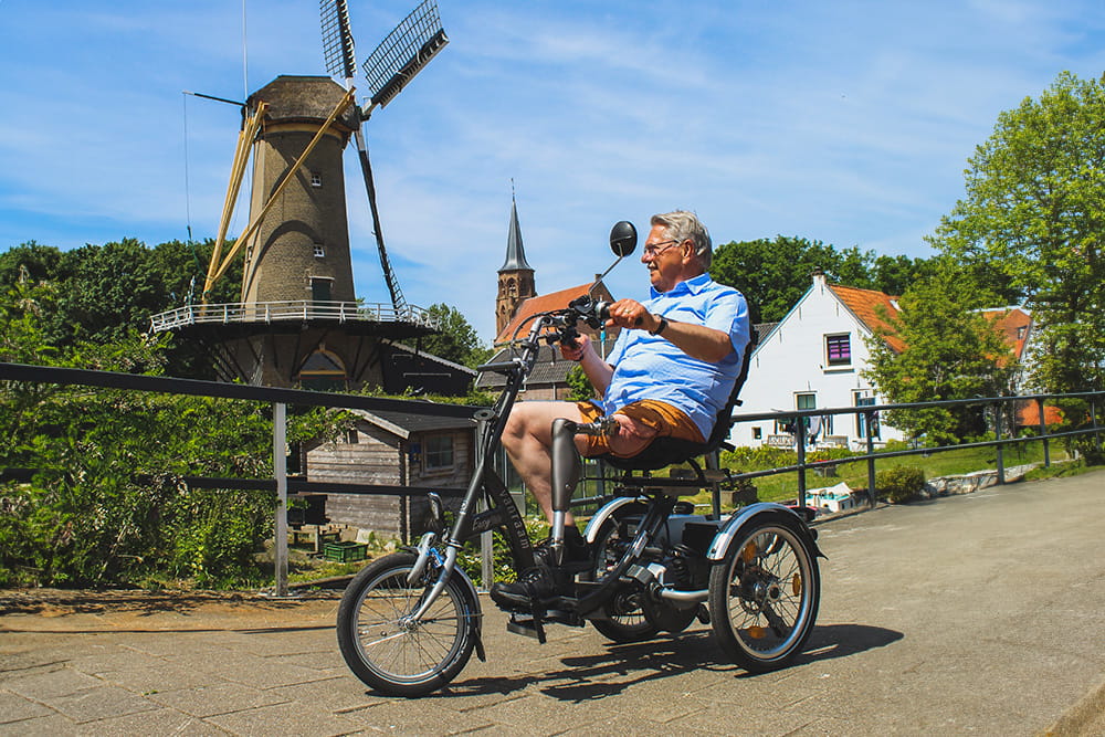 Ein Mann mit Endo-Exo-Prothese erkundet auf einem Trike eine Niederländische Stadt.
