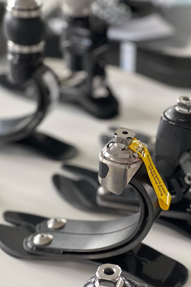 Auf einem Tisch stehen viele verschiedene Prothesenfüße.