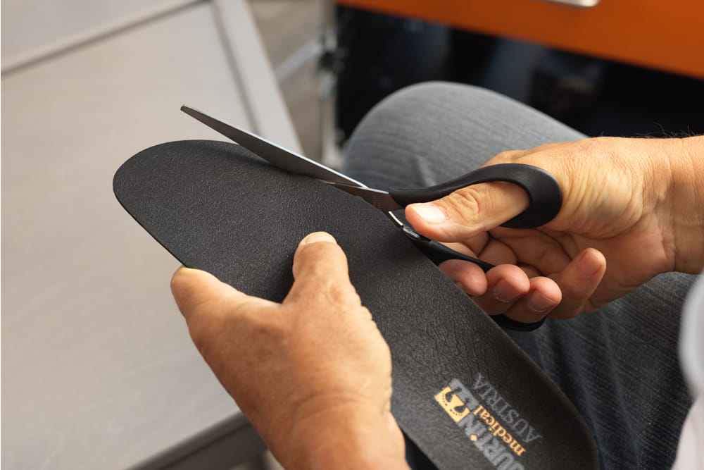 Ein Mann schneidet eine Einlage von Jurtin zurecht.