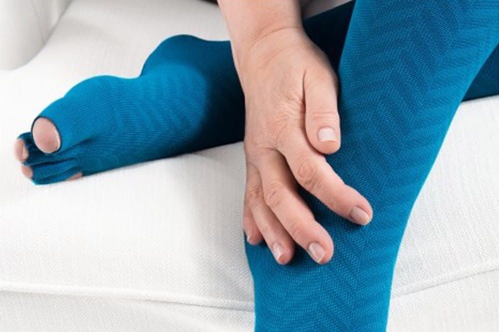 Eine Nahaufnahme von Füßen, welche Kompressionsstrümpfe von medi tragen, bei denen die Zehen frei sind.