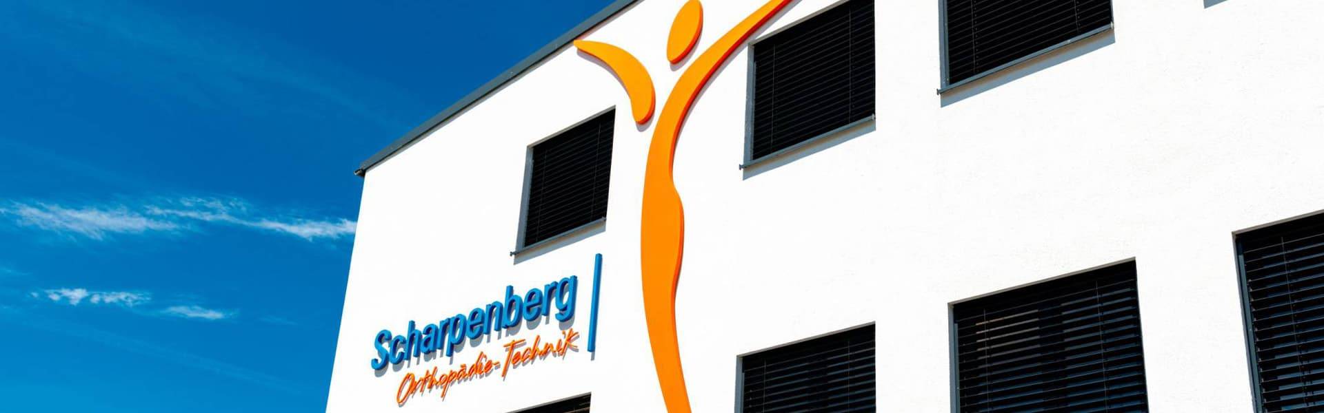 The headquarters of Orthopädie-Technik Scharpenberg with the logo on the wall of the building.